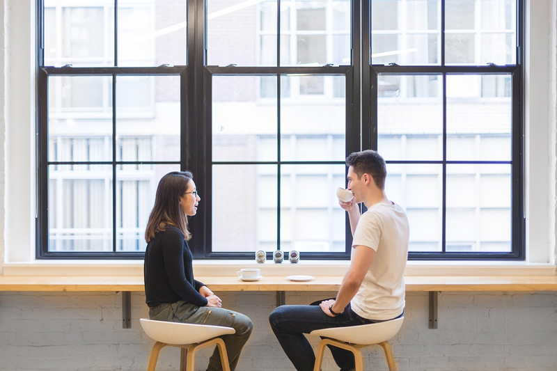 two people having friendly conversation over coffee at table