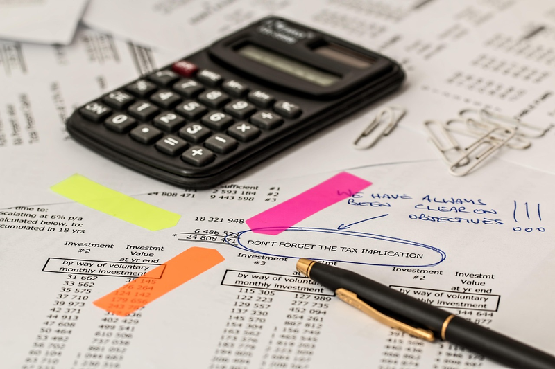 tax documents and calculator on desk with pen