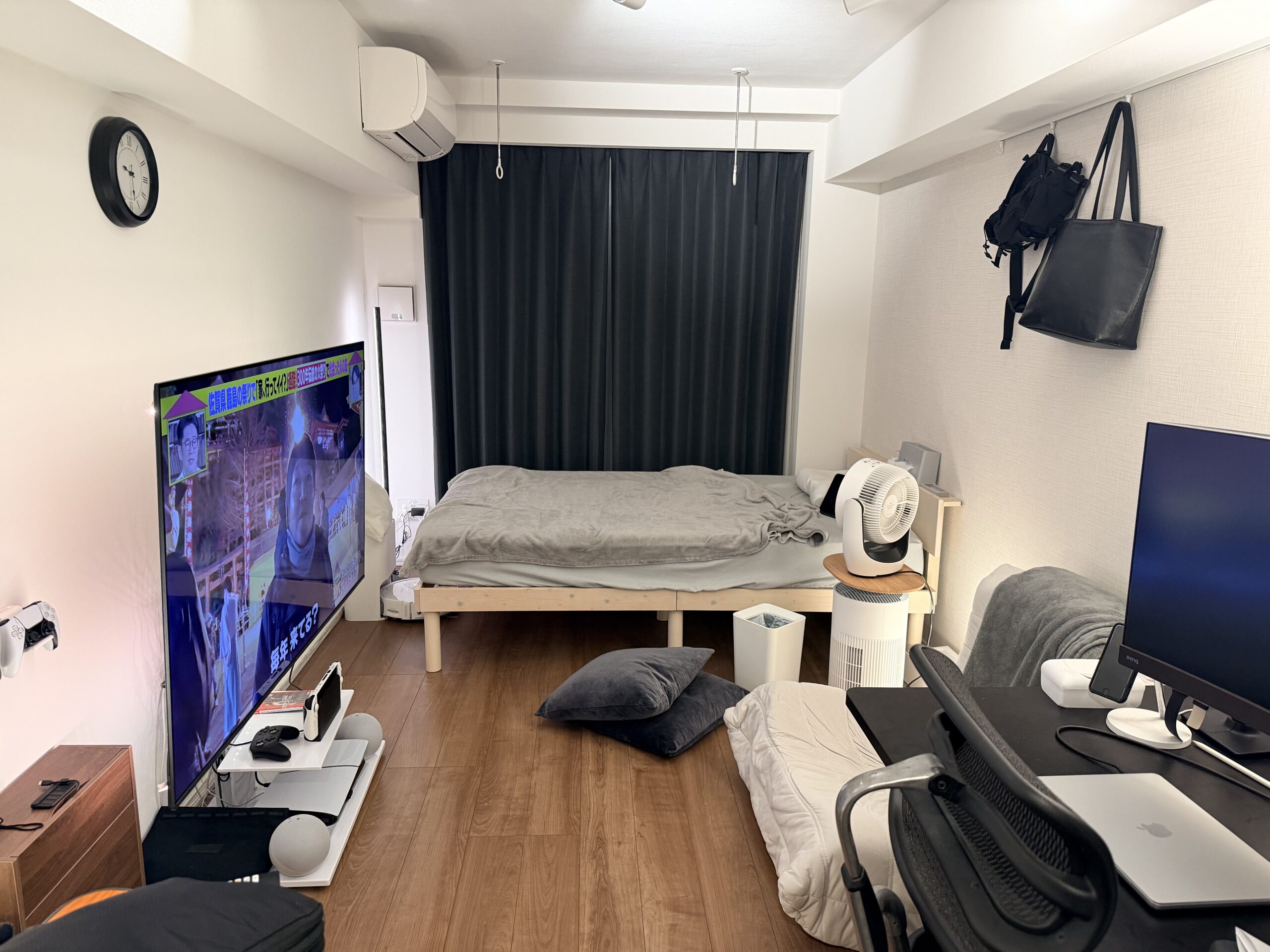 1K9畳の部屋に65インチテレビを設置した様子。左にテレビスタンド、右にPCデスク環境